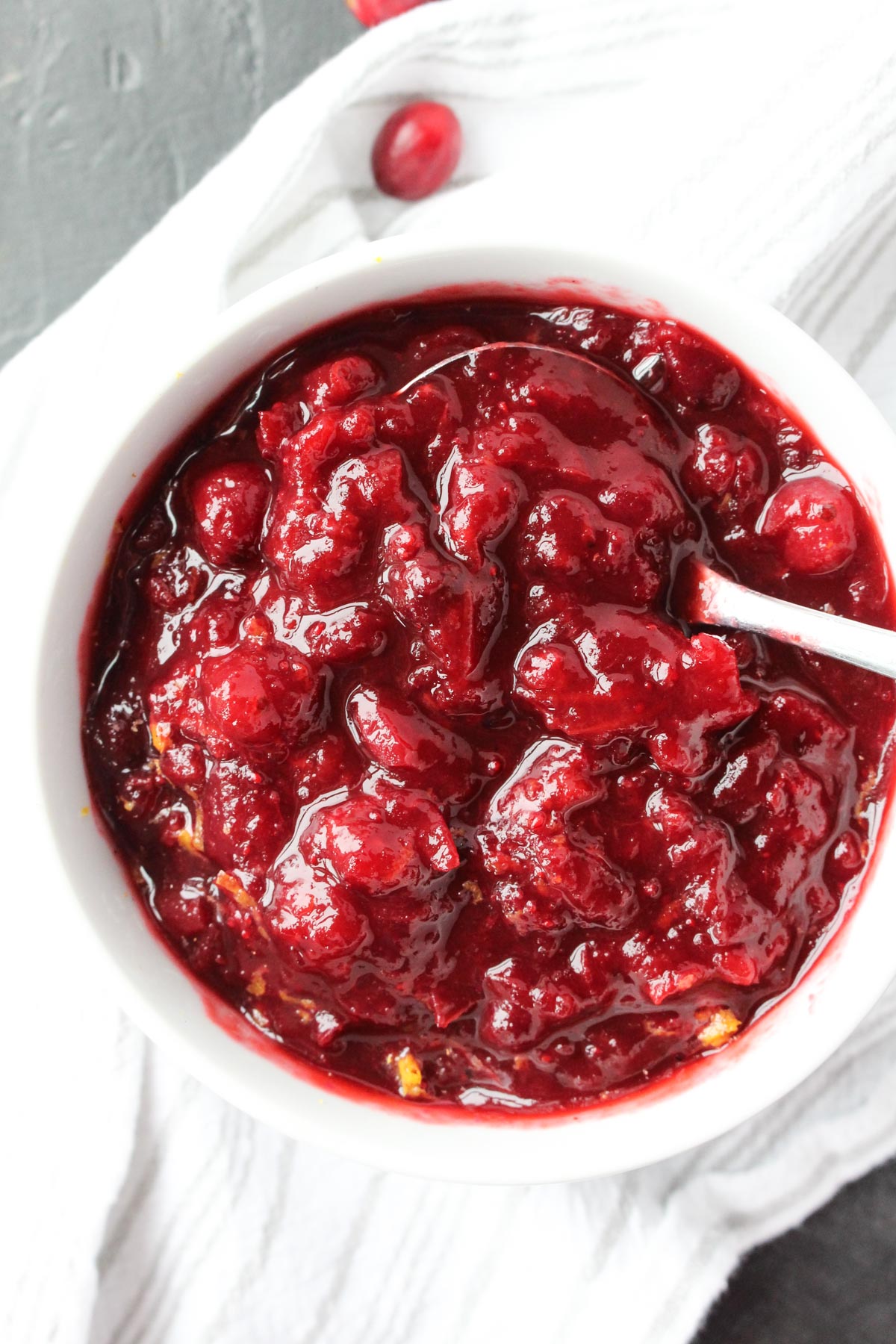 Overhead shot of cranberry sauce with serving spoon inside.