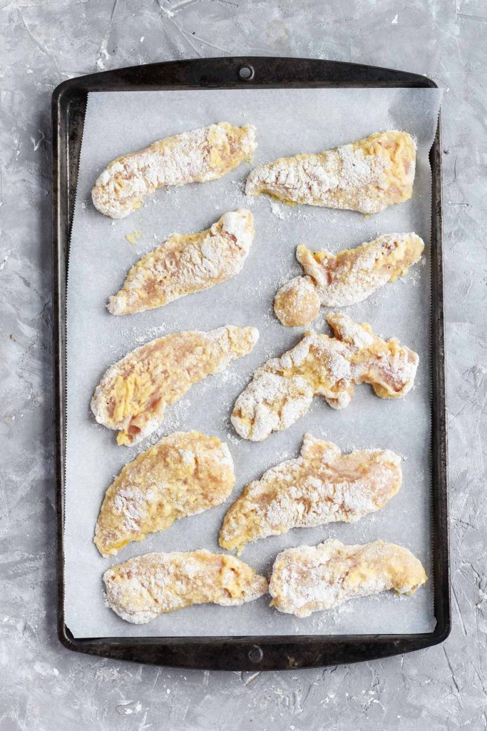 Chicken tenders on baking sheet.