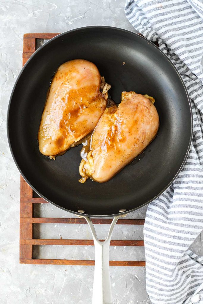 Chicken cooking on frying pan.