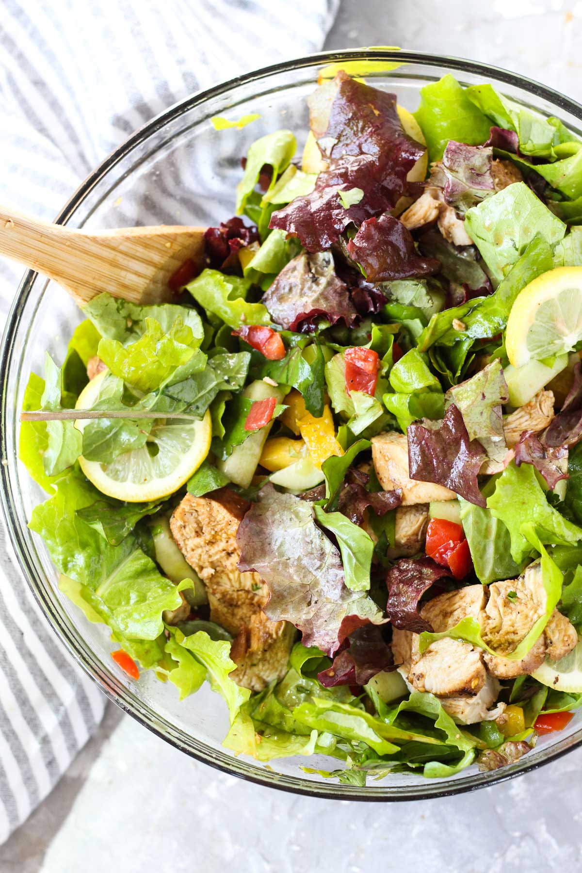 Salad tossed in large glass bowl.