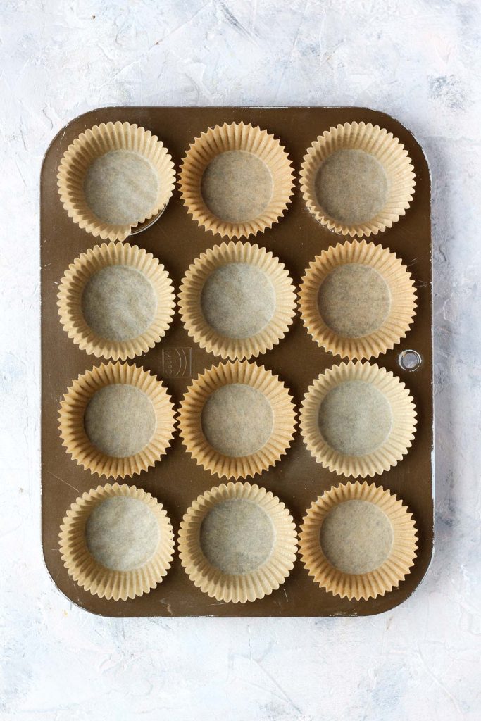 Muffin tin filled with parchment paper liners.
