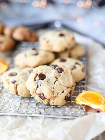 Cookies laid out on a table with fresh orange slices.