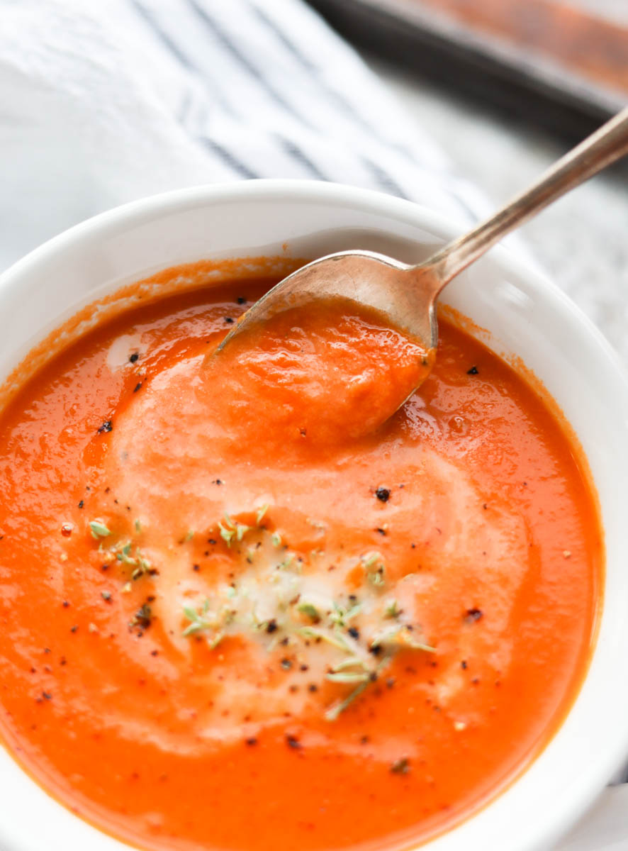 Spoon scooping carrot tomato soup.