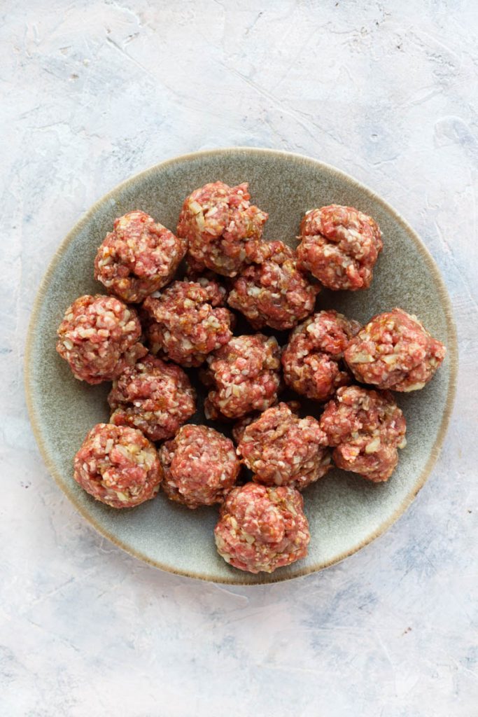 Meatballs rolled out on a plate.