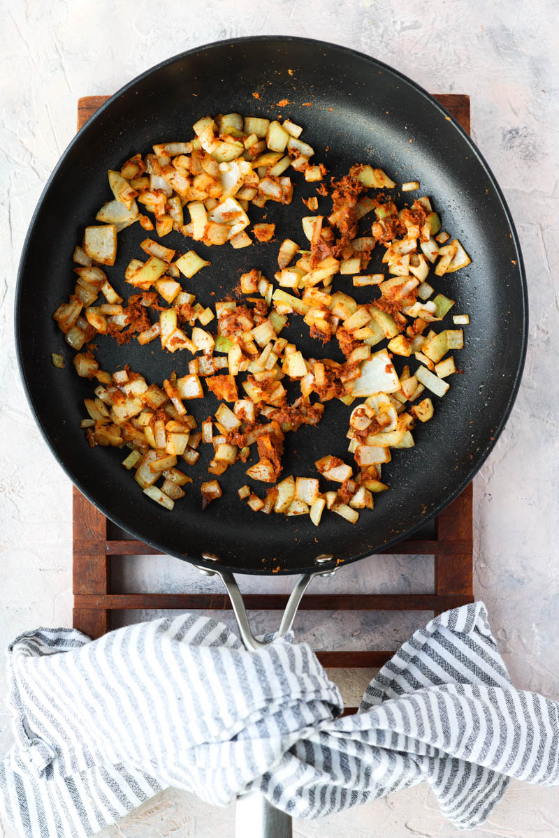 Onions cooking with red curry paste.