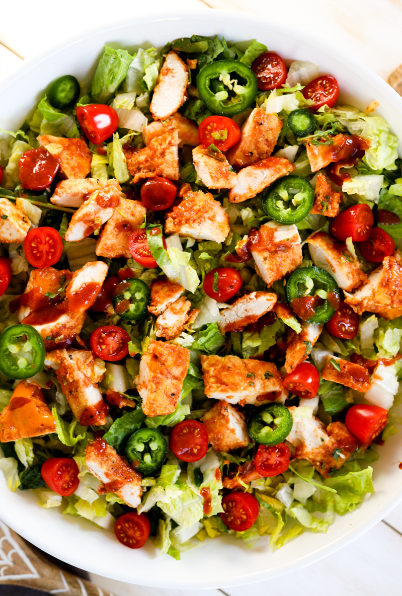 BBQ chicken salad in large white bowl.