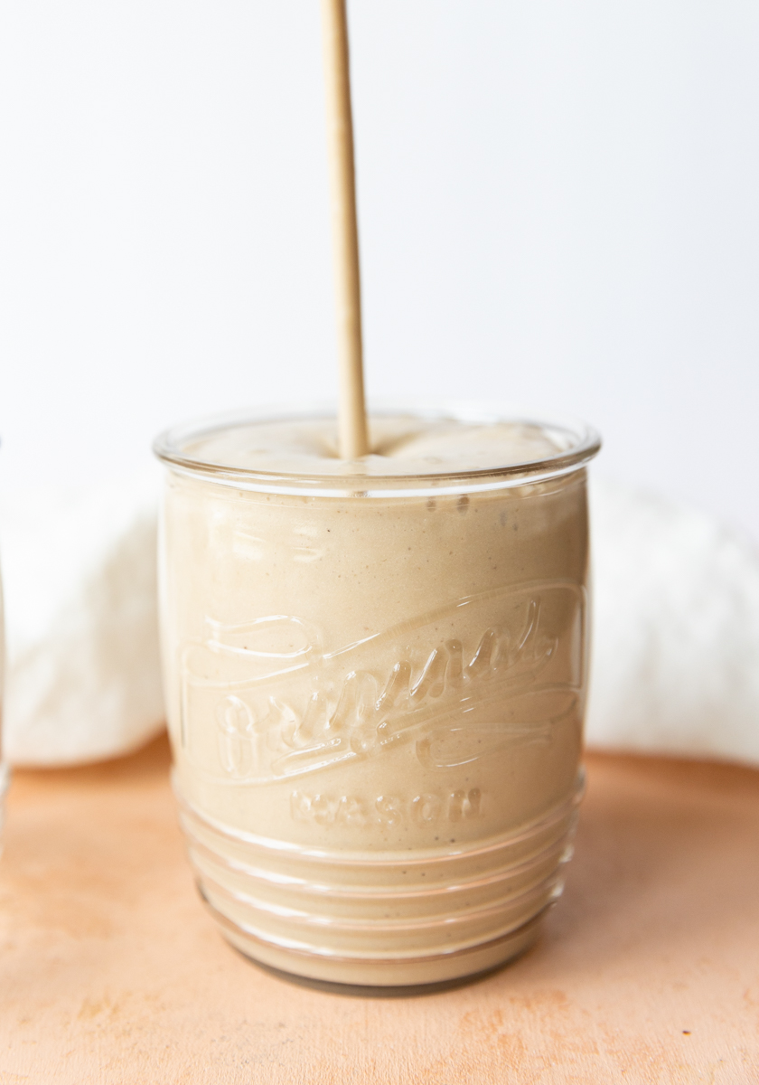 Coffee milkshake being poured into a glass cup.