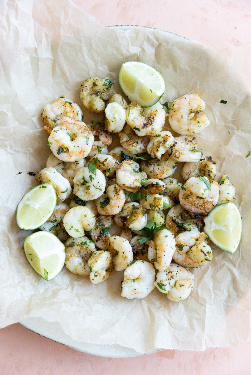 Grilled shrimp on a plate with parchment paper.
