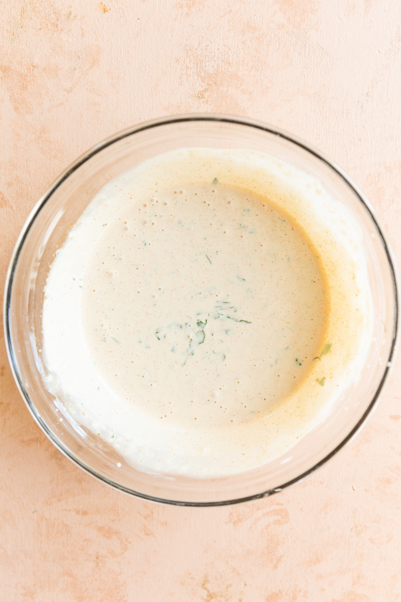 Creamy dressing in clear glass bowl.