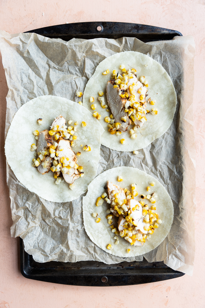 Tortillas with chicken breast and grilled corn.