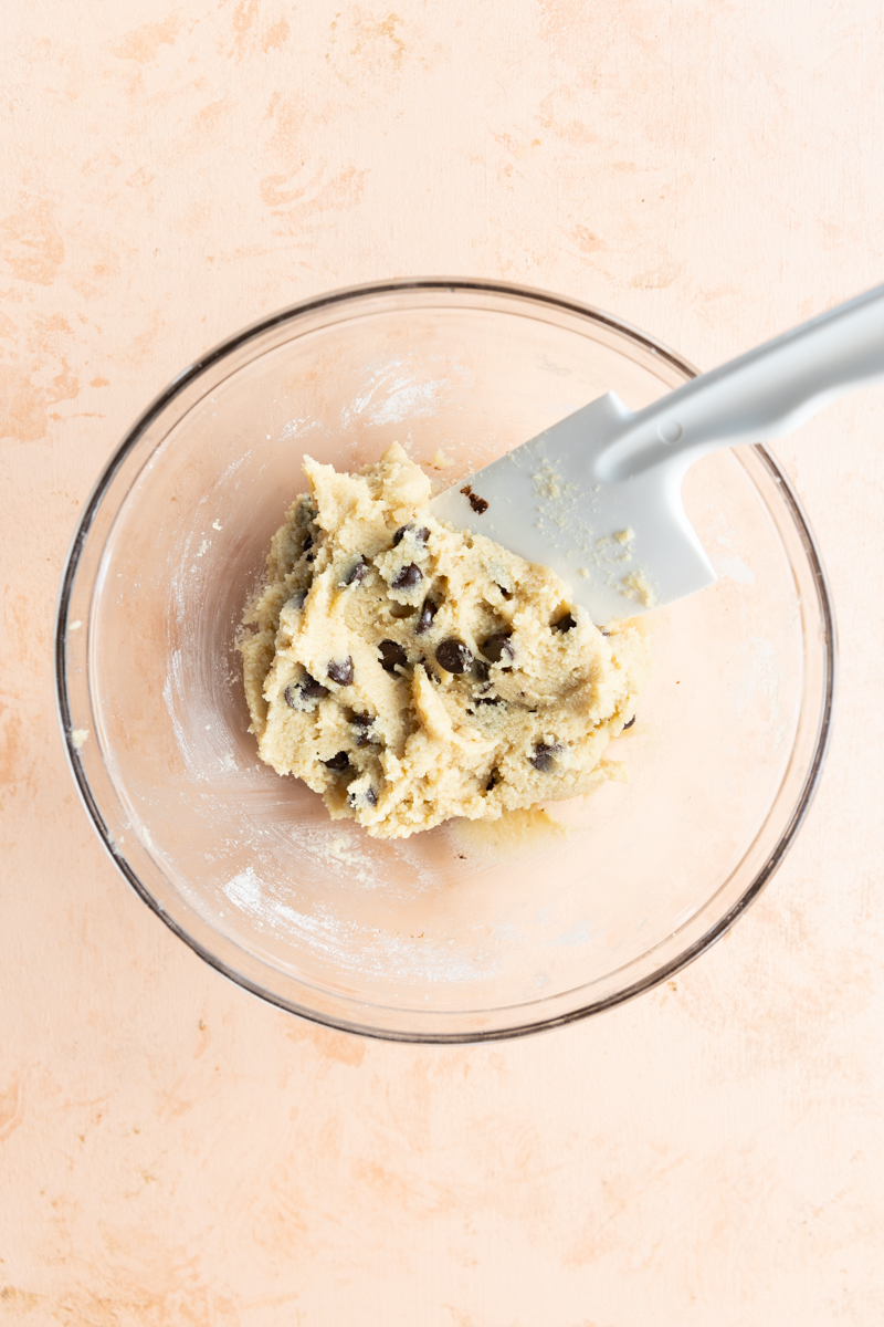 Cookie dough with chocolate chips in a mixing bowl.