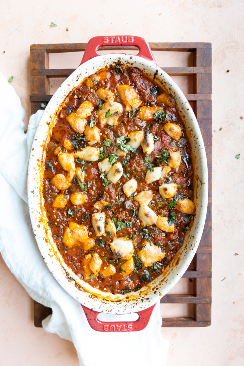 Baked Pizza Bowls in casserole dish with fresh basil on top.