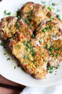 Close up picture of Italian Chicken Cutlets on a ceramic plate.