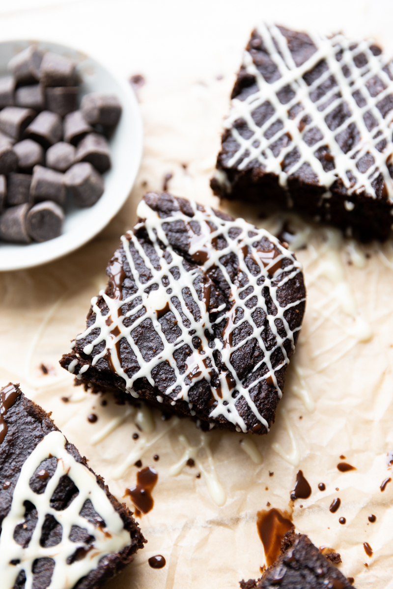 White chocolate spider web brownies on parchment paper.