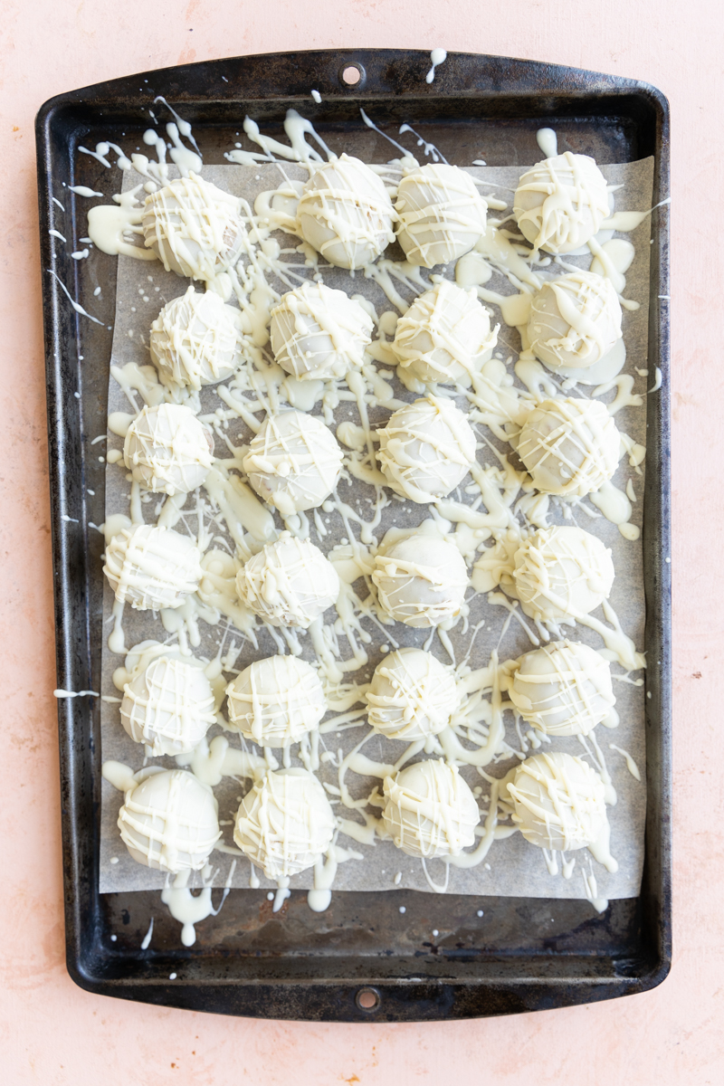 Cake pops drizzled with white chocolate.