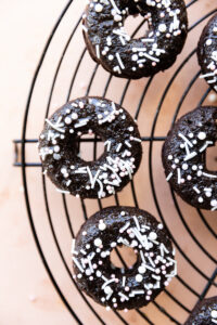 Gluten free chocolate mini donuts with sprinkles on top.