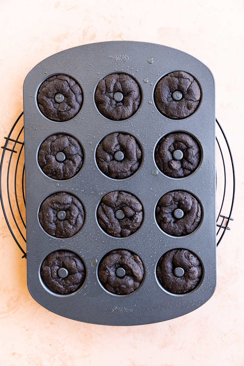 Baked chocolate mini donuts cooling in pan.