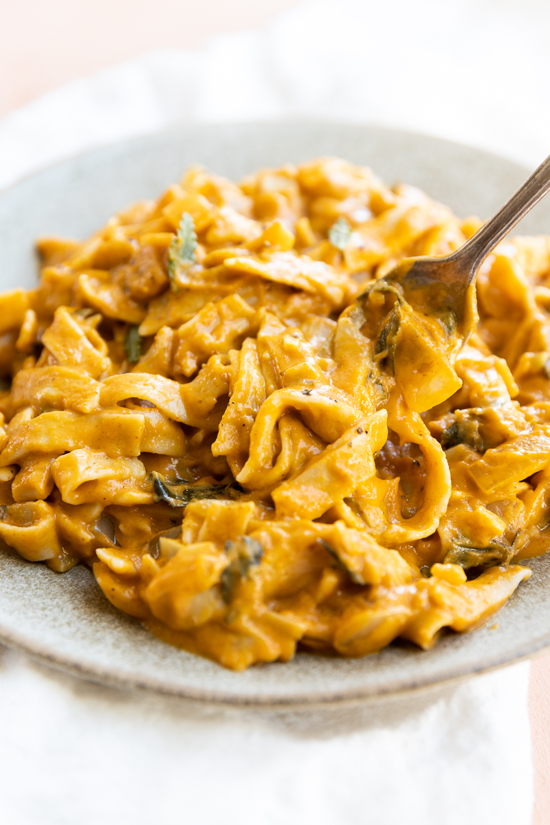 Fork twirling fettucine with pumpkin pasta sauce.