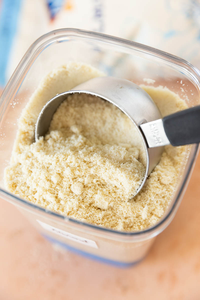 Close up picture of measuring cup in a jar with almond flour.