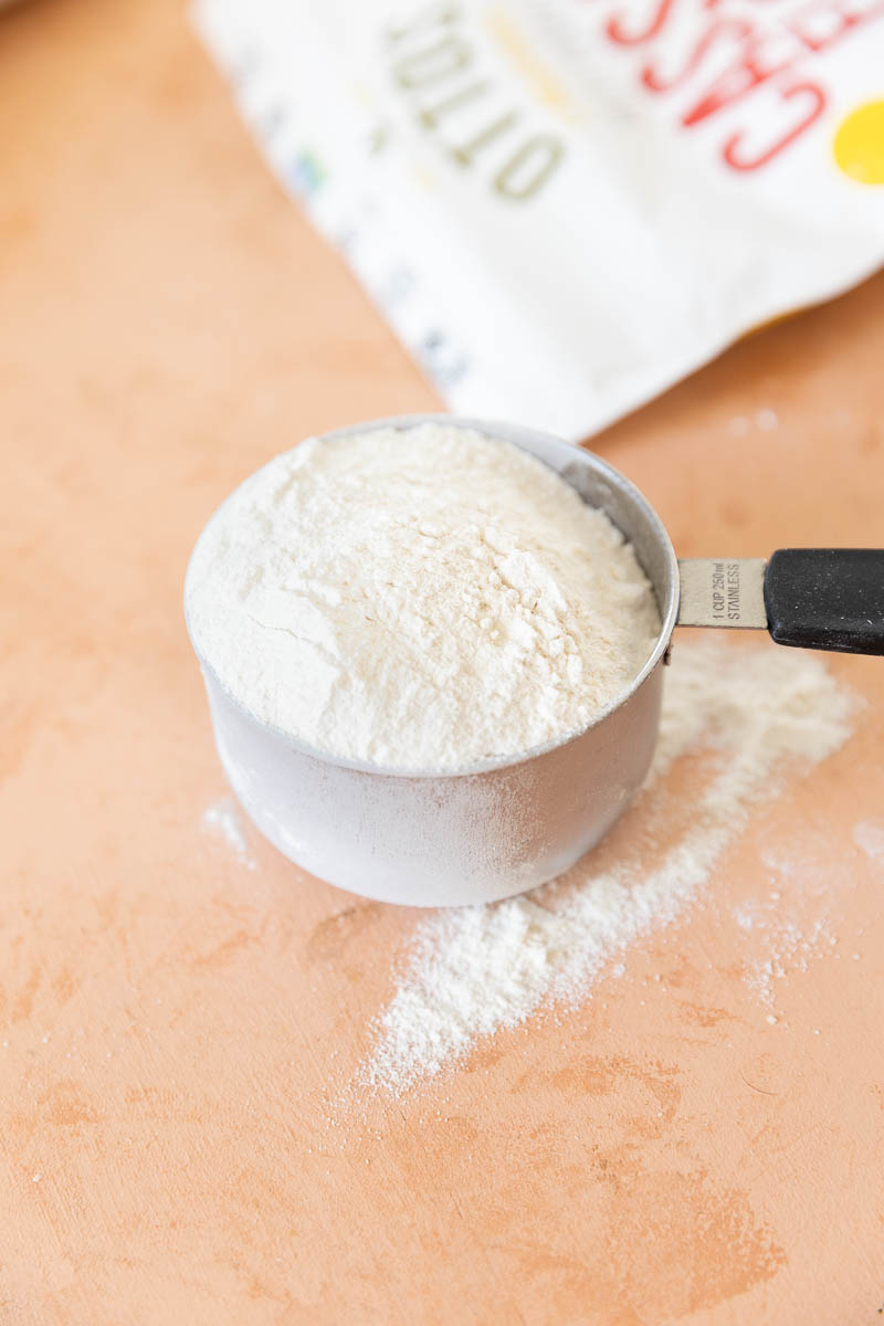 Cassava flour spilling out of measuring cup.