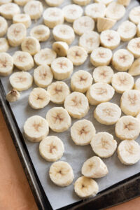 Close up of frozen green banana discs on a tray.