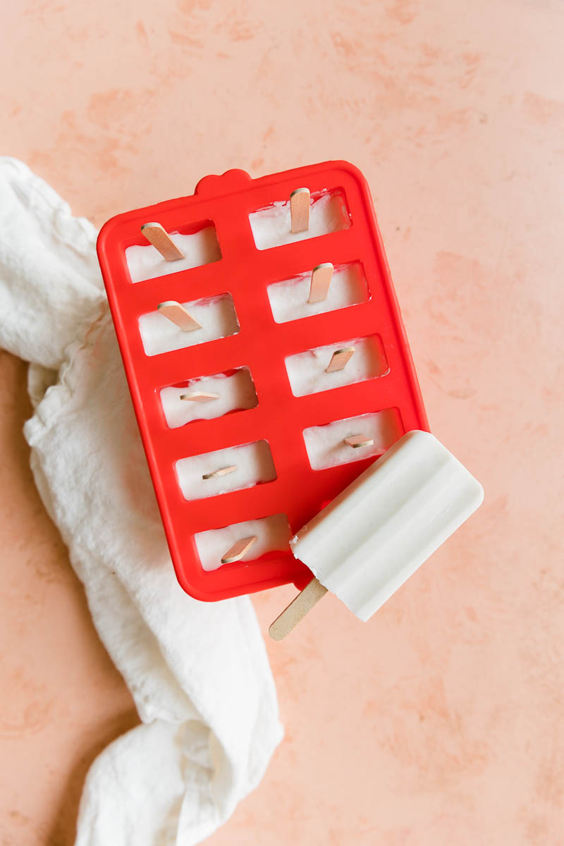 Overhead picture of frozen coconut ice cream bars in silicone mold.