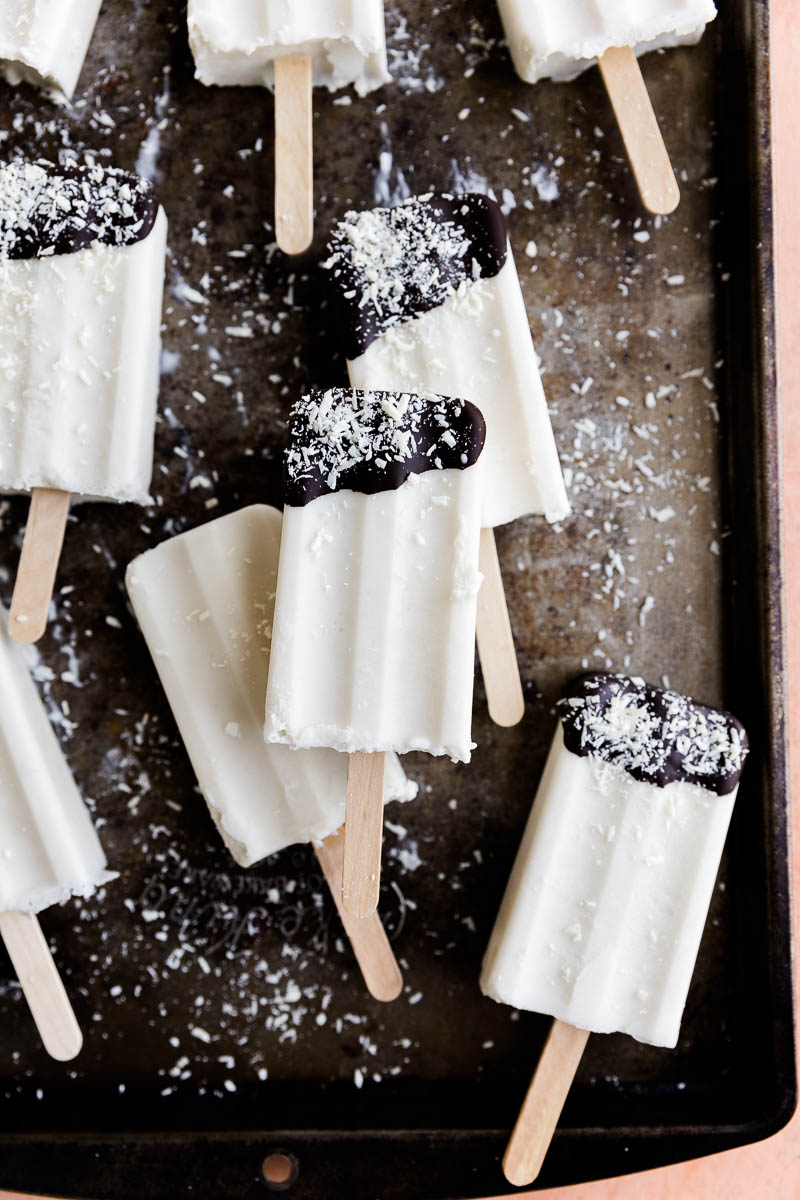 Coconut Ice cream bars dipped in chocolate with shredded coconut.