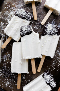 Coconut ice cream bars with a bite taken out of one.