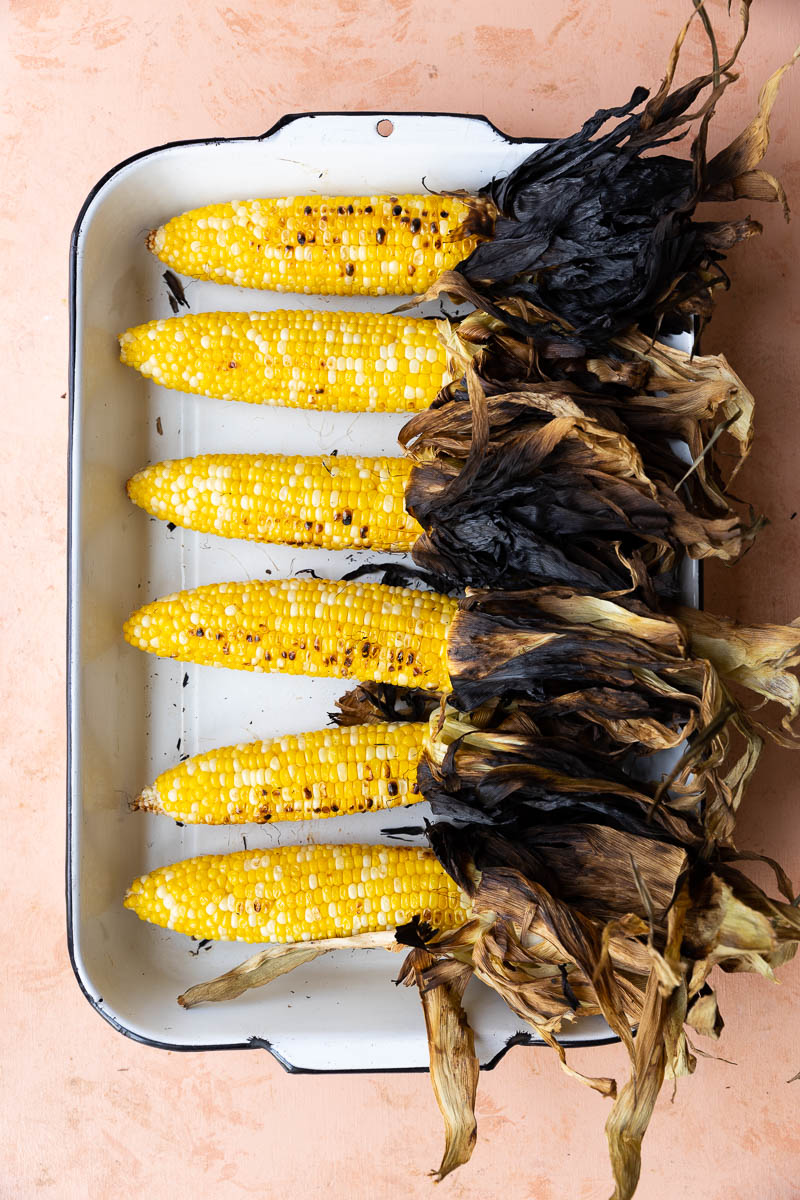 Charred corn on the cob with husk peeled down.