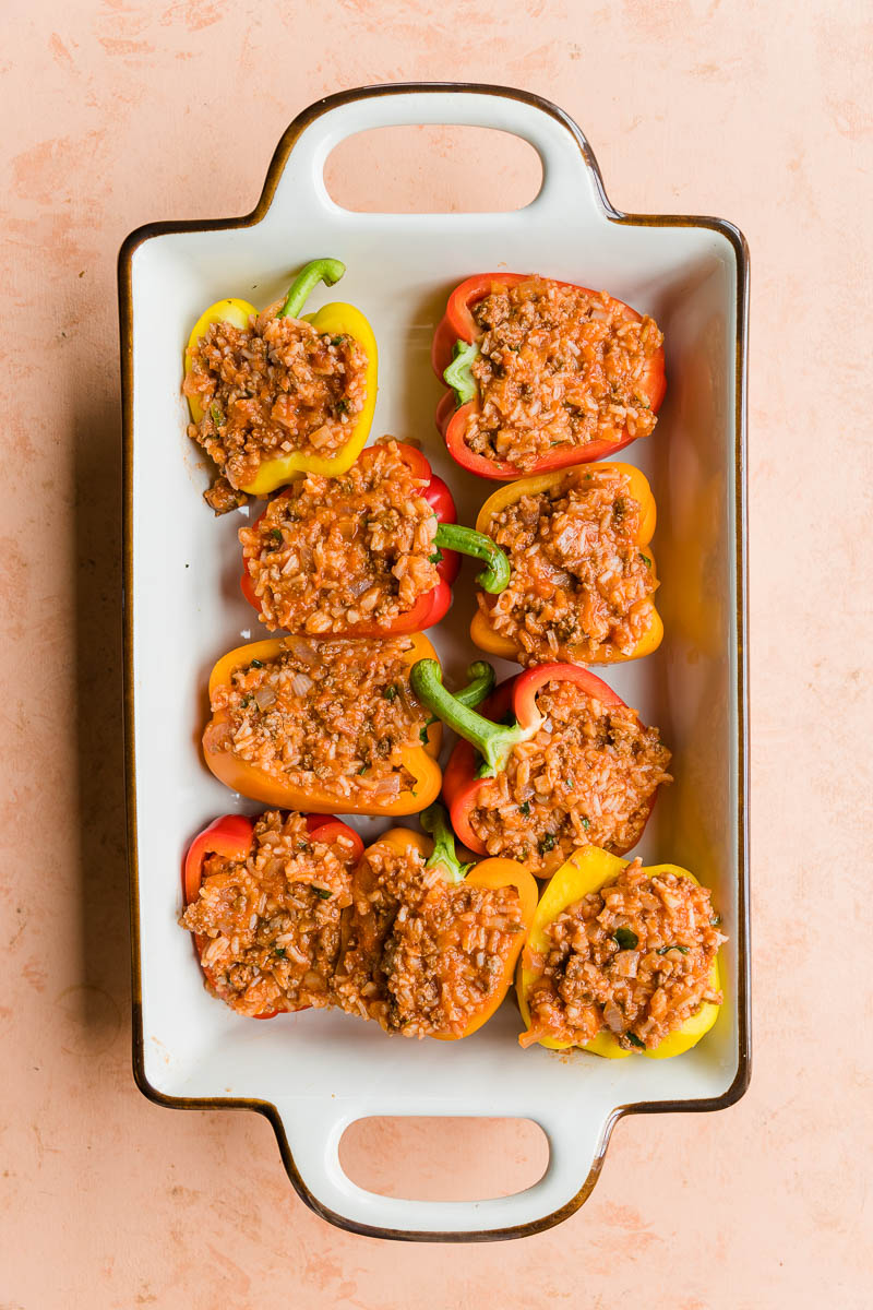 Stuffed peppers in a casserole dish before being cooked.