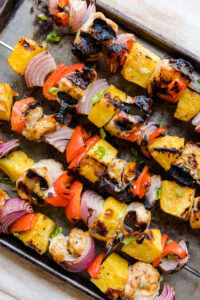 Chicken Teriyaki skewers on a black baking sheet.