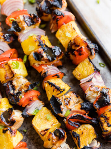 Close up picture of teriyaki chicken skewers with pineapple and veggies.
