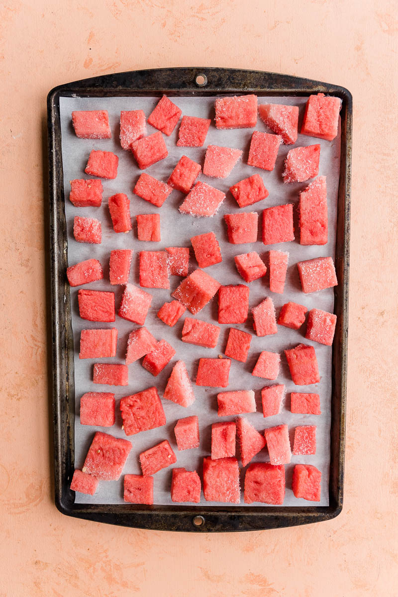 Frozen cubed watermelon on a baking tray.