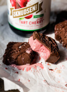 Cherry ice cream bars with a bite taken out.