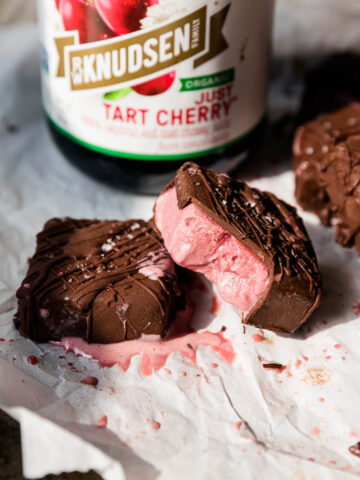 Cherry ice cream bars with a bite taken out.