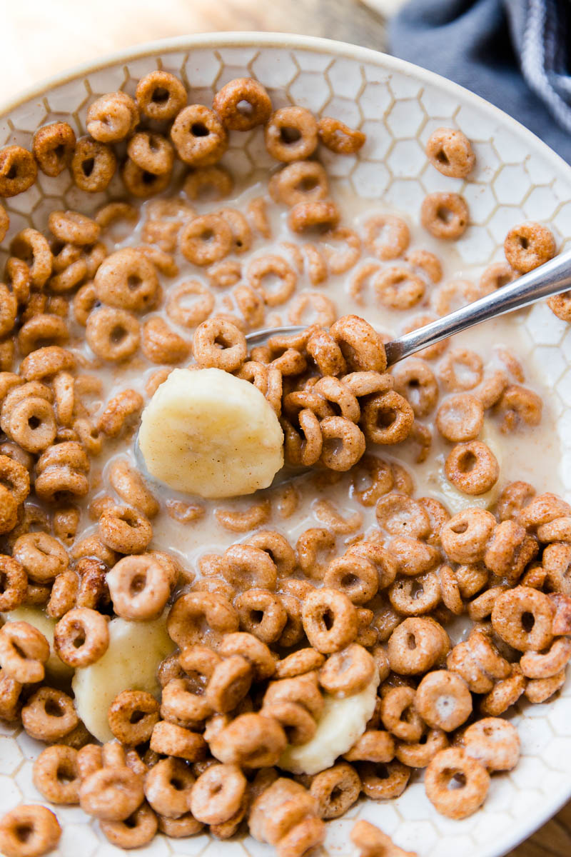 Spoon scooping out cereal with homemade almond milk.