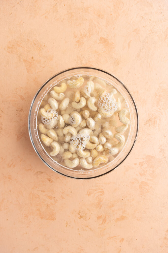 Raw cashews soaking in boiling water.