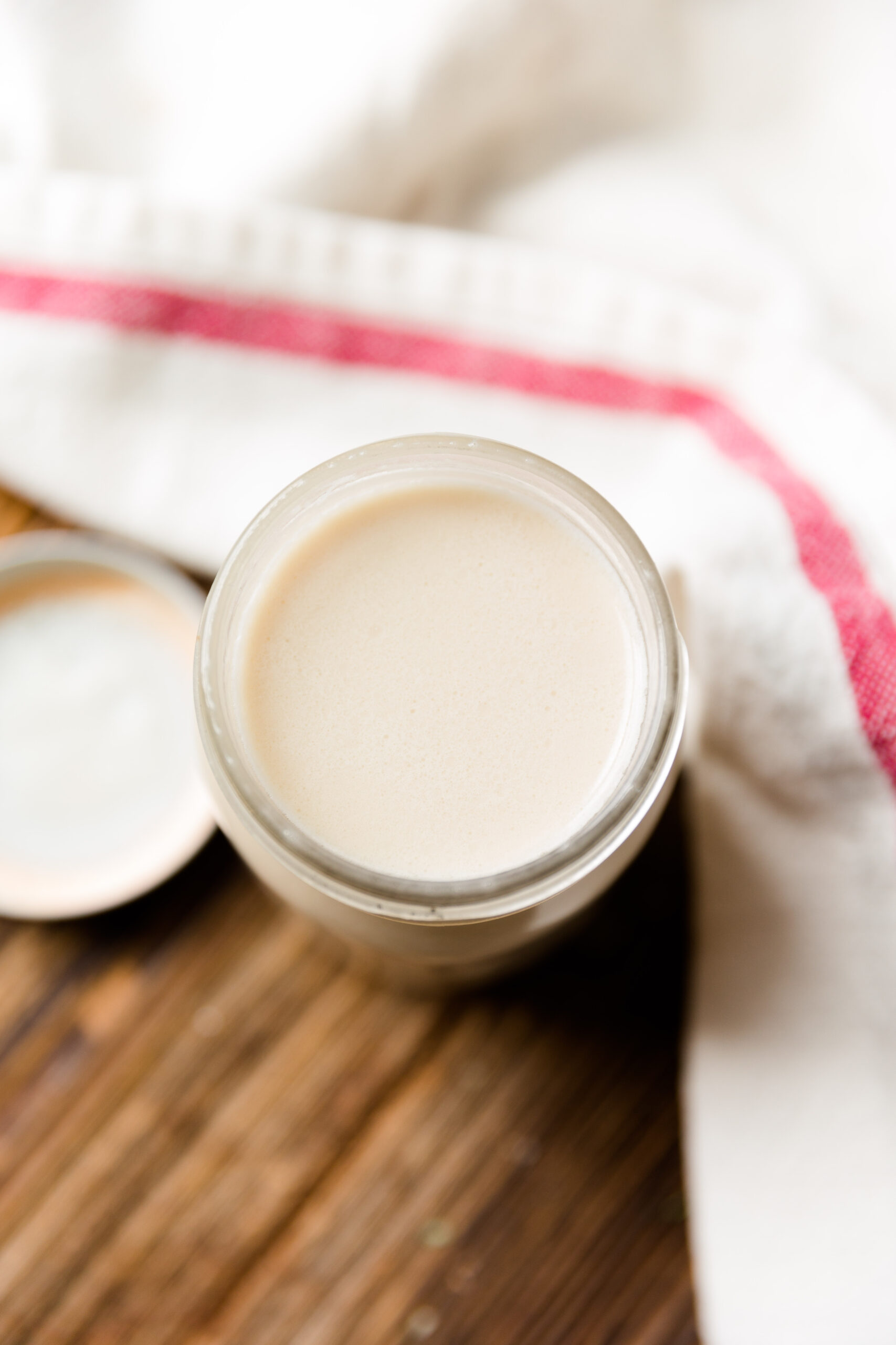 Overhead picture of vanilla creamer in glass mason jar with the lid on the side.