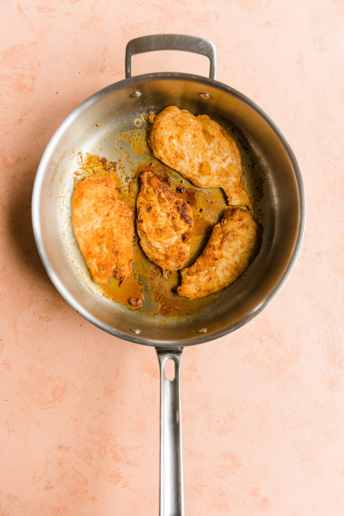 Cooked chicken breast in a pan.