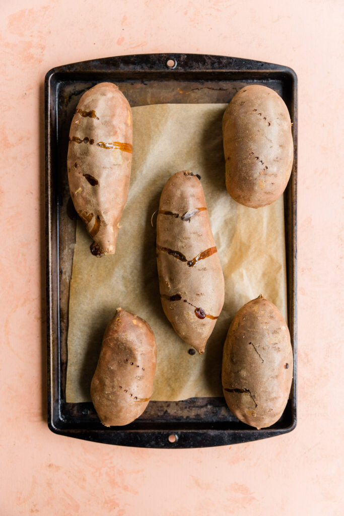 Baked sweet potatoes on baking sheet.