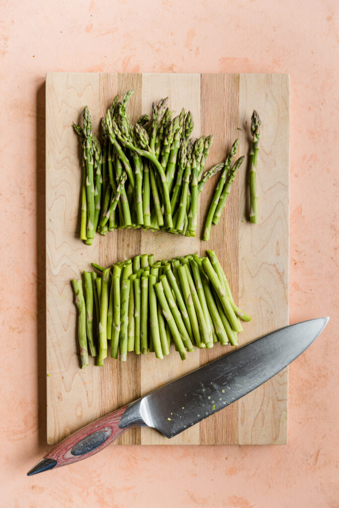 Asparagus cut in half on a cutting board.