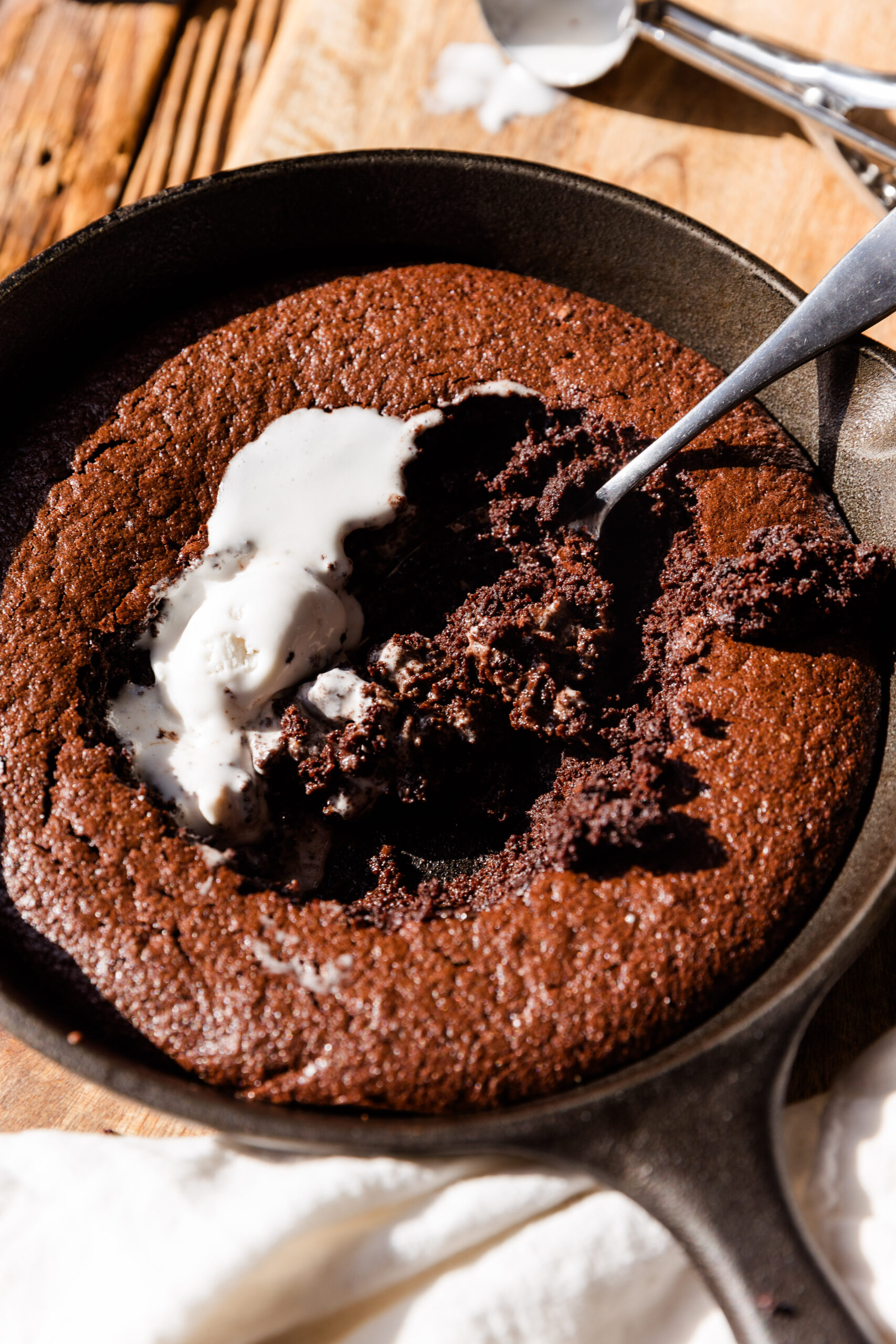 Gluten Free brownie skillet with spoon scooping out the gooey center.