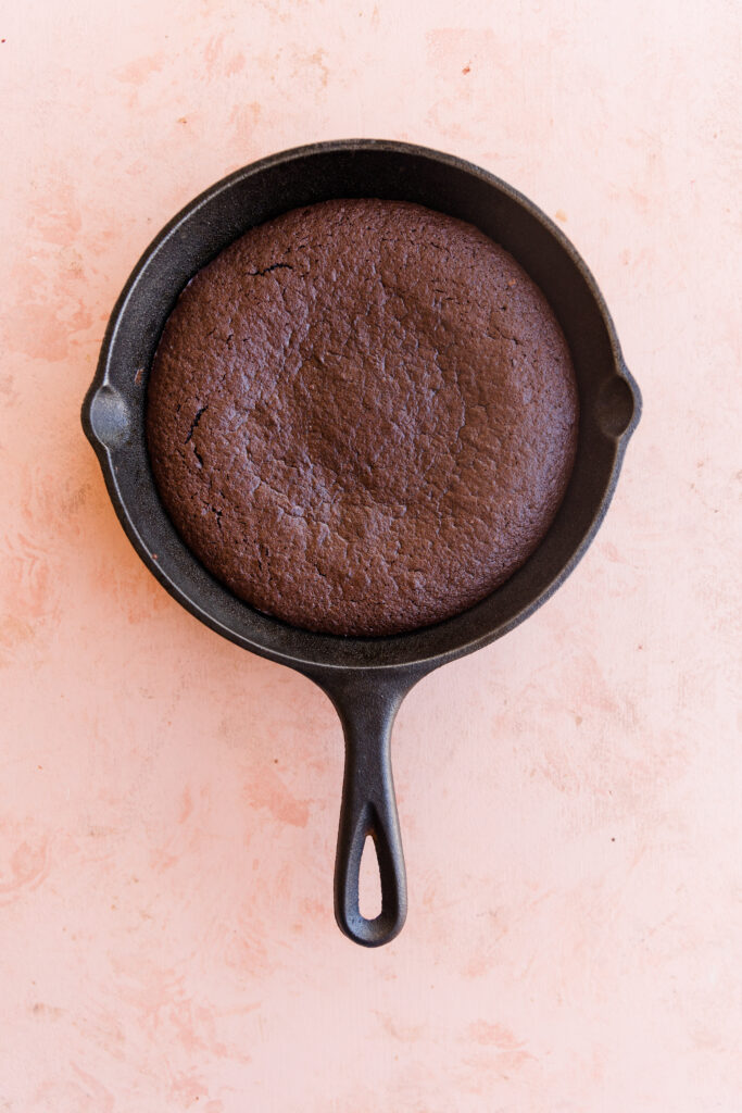 Baked brownie in cast iron skillet.
