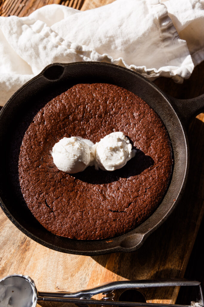 Brownie skillet with two scoops of coconut whipped cream on top.