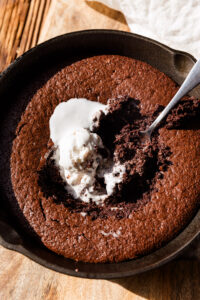 Gluten Free brownie skillet with spoon scooping out the gooey center.