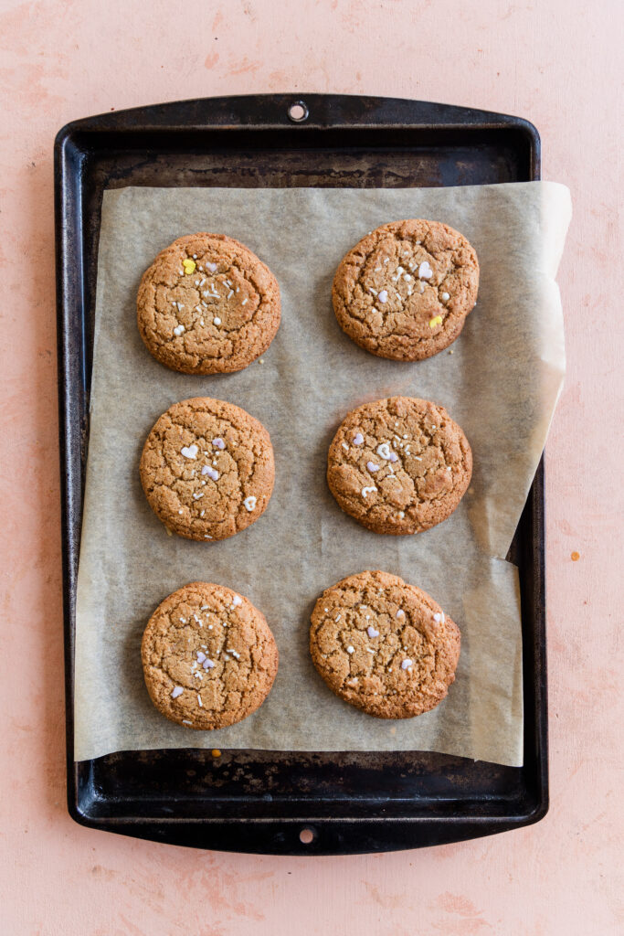 Gluten free funfetti cookies cooling on a parchment paper lined baking sheet.