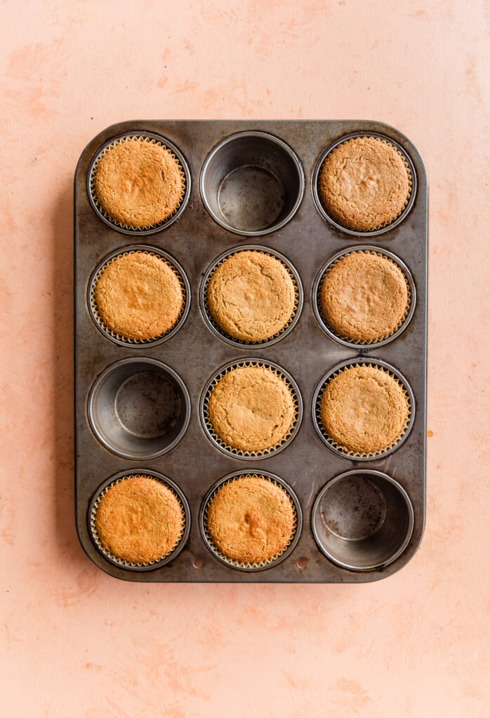 9 golden brown vanilla cupcakes in cupcake pan.