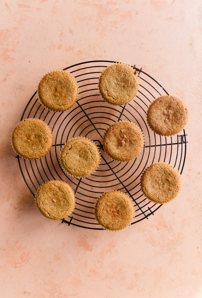 9 cupcakes cooling on metal rack.