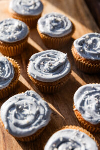 Gluten free vanilla cupcakes with blue frosting and white sprinkles.
