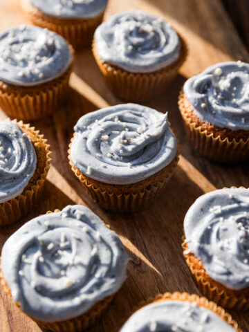 Gluten free vanilla cupcakes with blue frosting and white sprinkles.